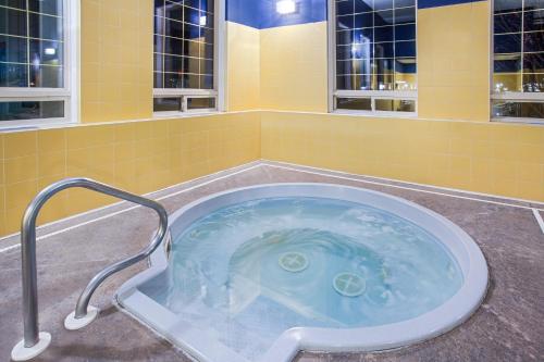 un jacuzzi en un baño con azulejos amarillos en Ramada by Wyndham Red Deer Hotel & Suites en Red Deer