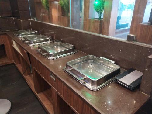 a bathroom counter with four sinks and a mirror at Hotel White Boutique in Puducherry