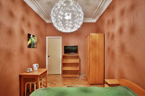 a living room with a chandelier and a bedroom at Fligel na Zhukovskogo in Saint Petersburg