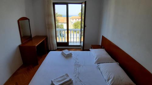 1 dormitorio con cama, espejo y ventana en Apartmani Ždrelac, en Ždrelac