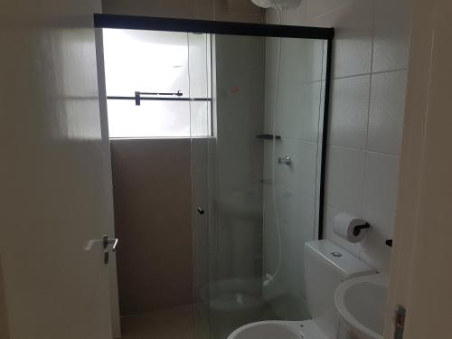 ein Bad mit einer Dusche, einem WC und einem Waschbecken in der Unterkunft AbeQuar apartamentos beira-mar para temporada in Itanhaém