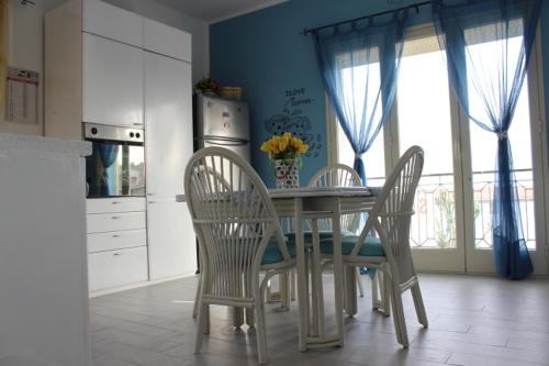 uma cozinha com uma mesa e cadeiras e uma cozinha com uma janela em Maré - Scala dei Turchi em Realmonte