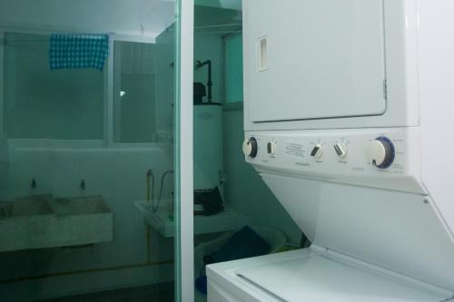 baño con lavabo y estufa blanca en Los Mangos, en Zihuatanejo