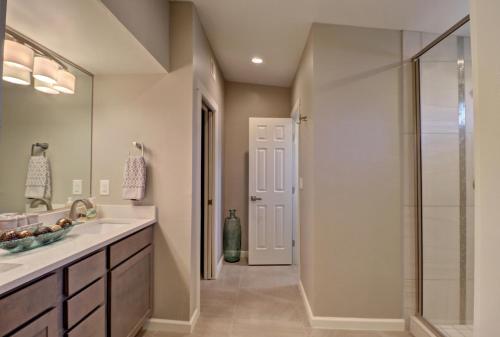 a bathroom with a shower and a sink and a glass door at Sleek, Modern Designer home 3 in Las Cruces