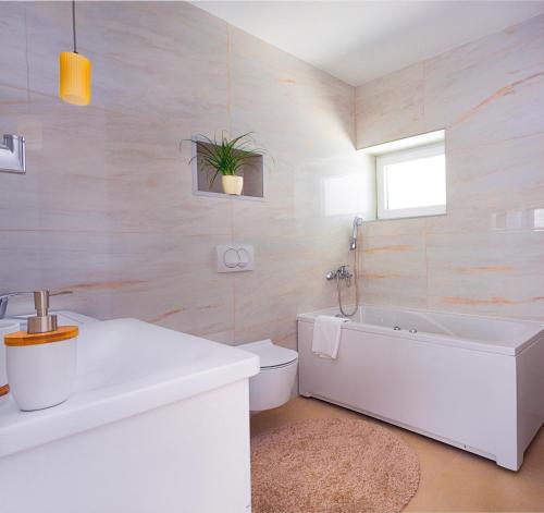 a bathroom with a tub and a toilet and a sink at Deluxe City Center Blue apartment in Split