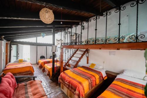 a group of beds in a room with a ladder at Hostal México Airport CDMX in Mexico City