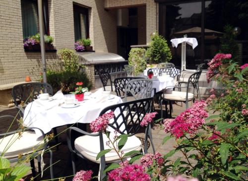 a patio with tables and chairs with pink flowers at Hotel Imperial in Cologne