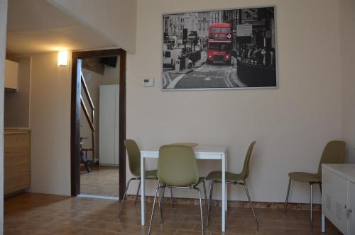 a dining room with a table and a red double decker bus at Dimora Sole Raggiante in Venosa