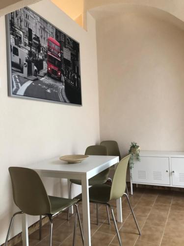a dining room with a white table and chairs at Dimora Sole Raggiante in Venosa