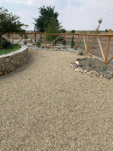 a garden with a stone wall and a fence at Southwestern Comfort Stay 2B in Las Cruces