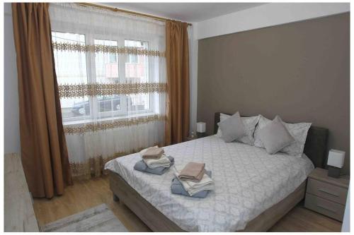 a bedroom with a bed with two towels on it at The Apartment Sinaia in Sinaia