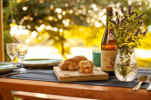 a table with a bottle of wine and a loaf of bread at La Maison de Dame Holda in Tanville