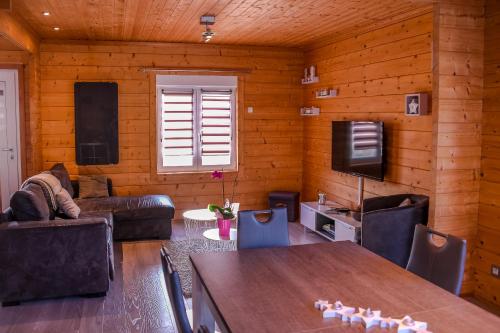 a living room with a table and a television at Insolite maison bois, wifi Netflix, au coeur de l'Argonne et des batailles de Verdun in Chaudefontaine