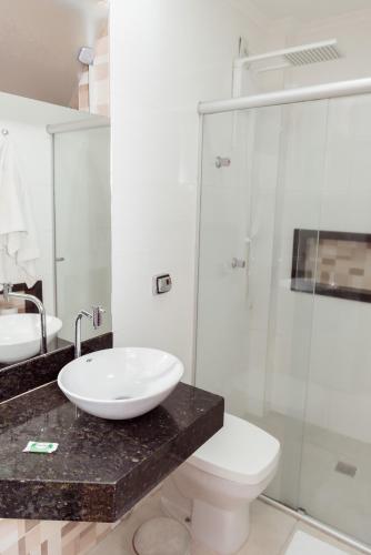a bathroom with a sink and a toilet and a shower at Castelar Novo Hotel in Varginha
