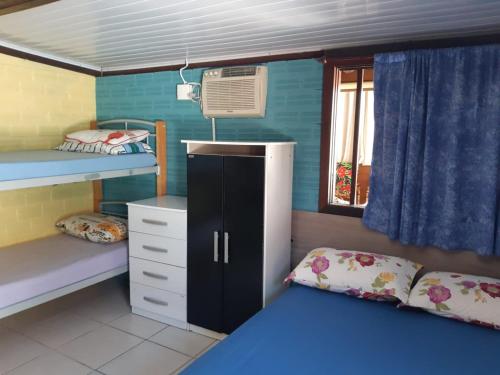a dorm room with a bunk bed and a desk at Recanto do Sol Pousada in Capão da Canoa