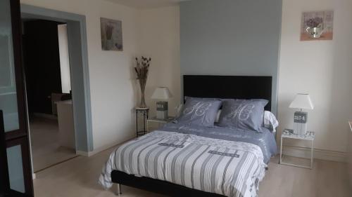 a bedroom with a bed and two lamps in it at Les Hauts de Proisy in Proisy