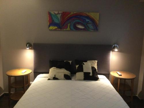 een slaapkamer met een bed met 2 tafels en een schilderij bij Bellavista XIV in Mar del Plata