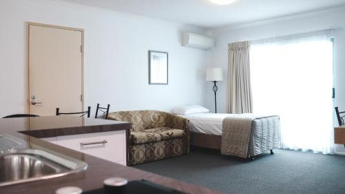 a hotel room with a bed and a couch at Heritage Cairns Hotel in Cairns