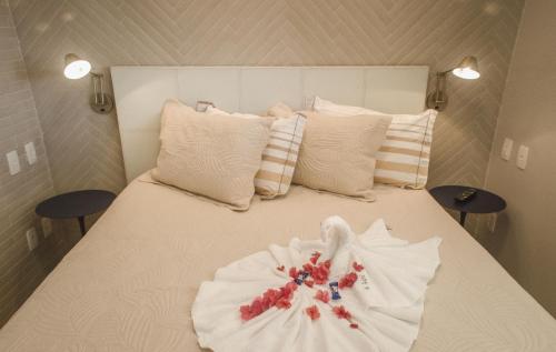 un letto con un fiore fatto di asciugamani di Flat LUXO Porto de Galinhas Muro Alto a Porto De Galinhas