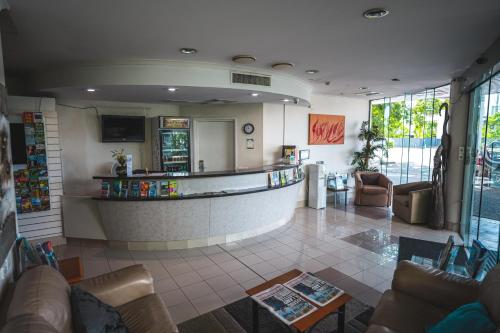 a lobby with couches and a bar in a building at Heritage Cairns Hotel in Cairns