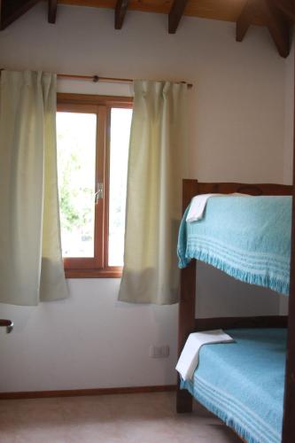Un dormitorio con dos literas y una ventana. en Acuarela, en Villa Gesell