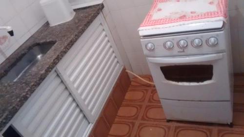 a kitchen with a white stove and a sink at Pousada Pantanal in Itanhaém