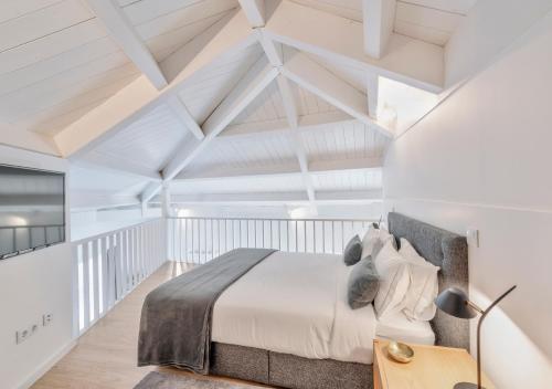 Un dormitorio con una cama en una habitación blanca. en Oporto Comfort Dom Hugo - Historic Apartments, en Oporto