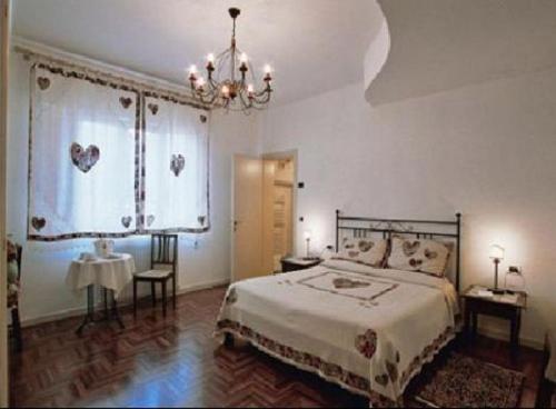 a bedroom with a bed and a chandelier at Casa del Miele in Tessera