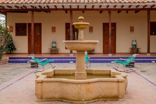a fountain in the middle of a courtyard with chairs at Hotel Marquesa de Pinares in Tibasosa