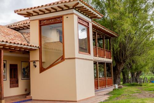 a house with a large window on the side of it at Hotel Marquesa de Pinares in Tibasosa