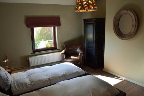 1 dormitorio con 1 cama, 1 silla y 1 ventana en Villa des Roses Voltaire, en Bruselas