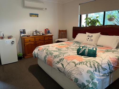 Schlafzimmer mit einem Bett, einem Tisch und einem Fenster in der Unterkunft Thistle Do Bed and Breakfast in Bridgetown