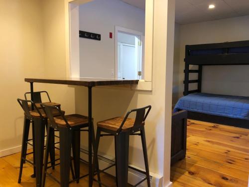 a bar in a room with three chairs and a bunk bed at Trailside Inn in Killington