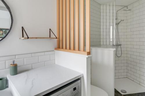 La salle de bains est pourvue d'un lavabo, de toilettes et d'une douche. dans l'établissement Sublime duplex Nantes Cathédrale, à Nantes