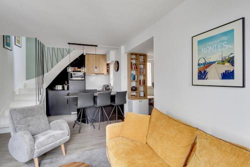 a living room with a couch and a kitchen at Sublime duplex Nantes Cathédrale in Nantes