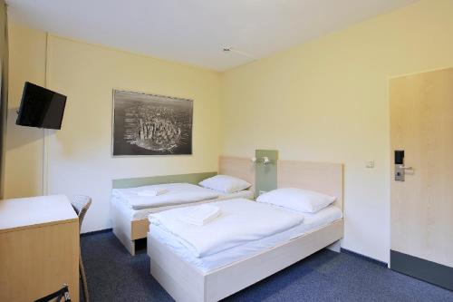a hotel room with a bed and a desk at Best Deal Airporthotel Weeze in Weeze