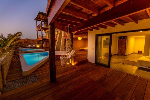 a villa with a swimming pool on a wooden deck at Casas Lua & Mar - Vichayito - Máncora in Vichayito
