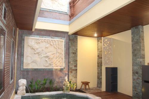 einen Pool in einem Raum mit einem Gemälde an der Wand in der Unterkunft The Garuda Homestay Sanur in Sanur