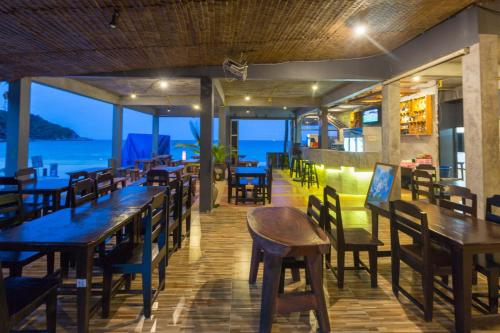 a restaurant with tables and chairs and a view of the ocean at Sunrise Resort- Koh Phangan - SHA Extra Plus in Haad Rin