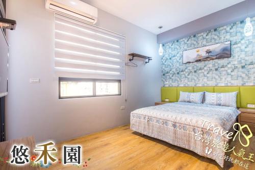 a bedroom with a large bed and a window at Host Garden悠禾園 in Hualien City