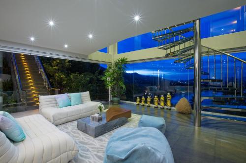 a living room with white furniture and a large window at Panoramic Duplex Studio in Chaweng Noi Beach
