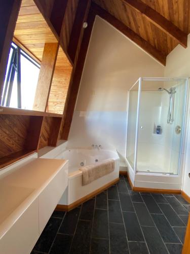a bathroom with a large tub and a shower at Arches on Bendrose in Twizel