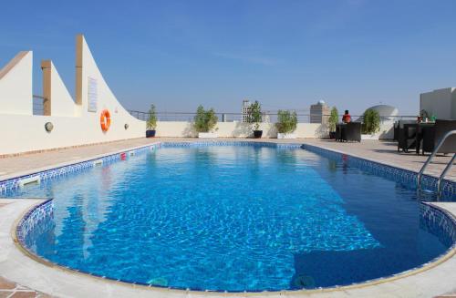 a large blue swimming pool on top of a building at Skylark Hotel Apartments AL Barsha in Dubai
