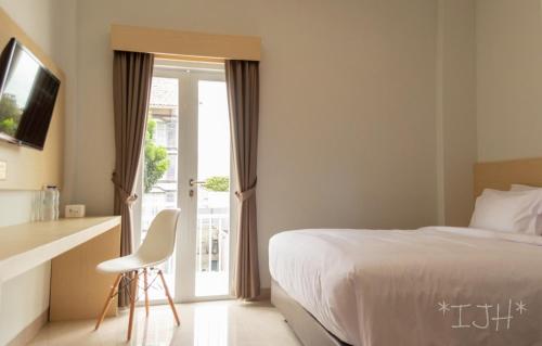 Cette chambre comprend un lit et une porte coulissante en verre. dans l'établissement Mahakam24 Residence, à Jakarta