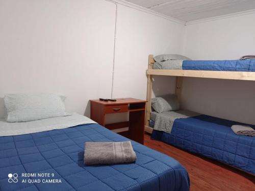 a bedroom with two bunk beds and a night stand at Hospedaje curicó casa grande in Curicó