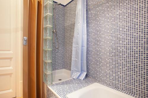 a bathroom with a shower with a toilet and a sink at Modernist Apartment Barcelona in Barcelona