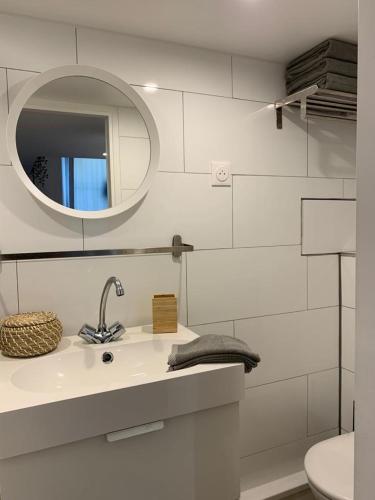 une salle de bain blanche avec un lavabo et un miroir dans l'établissement Loft Luxe La Plaine, à Marseille