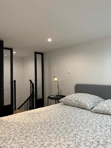 une chambre avec un lit et une table avec une lampe dans l'établissement Loft Luxe La Plaine, à Marseille