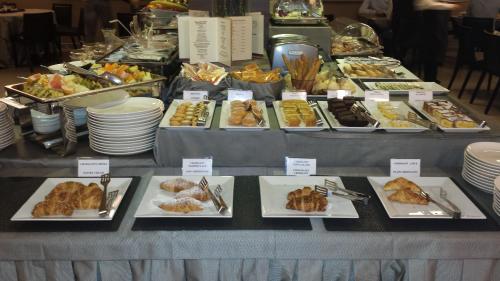 a table filled with different types of food on plates at Best Western Plus Hotel Monza e Brianza Palace in Cinisello Balsamo