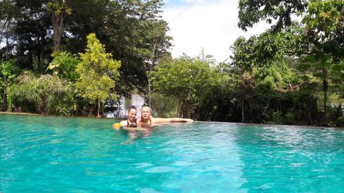 a man and a woman in a swimming pool at Vimanra Udawalawa in Udawalawe